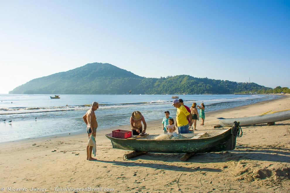 Imagem de turistas aguardando o peixe ser limpo.